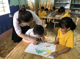 Cô giáo hướng dẫn Bùi Bá Tuyên vẽ tranh ( trẻ bị DOWN).jpg